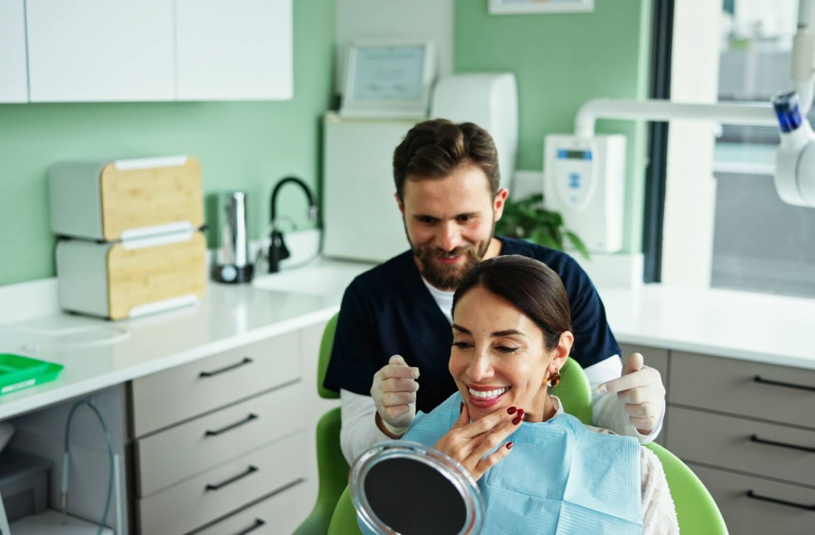 Dentist and patient smiling together in a bright modern dental clinic emphasizing care and oral health