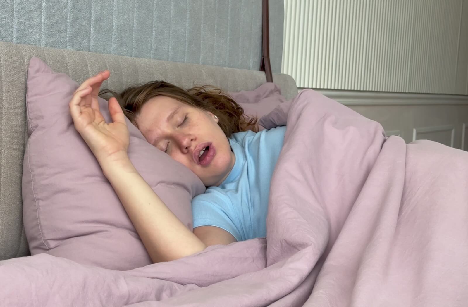 Woman sleeping on her back with mouth open, showing a common sign of sleep apnea.