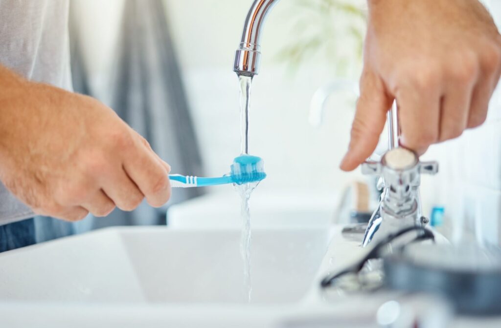 Close-up of a toothbrush under running tap water.